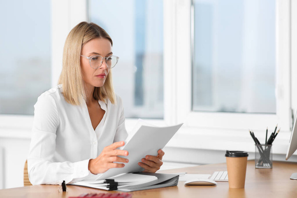 Woman working with documents at wooden table in office - Foto, Imagem