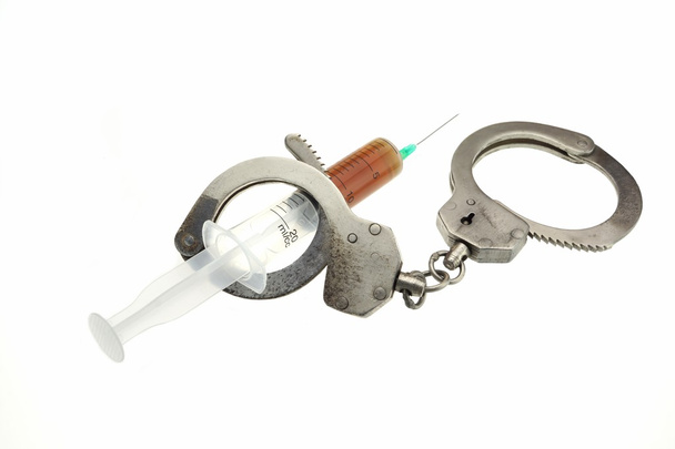 手錠と分離された茶色の液体を注射器 - 写真・画像