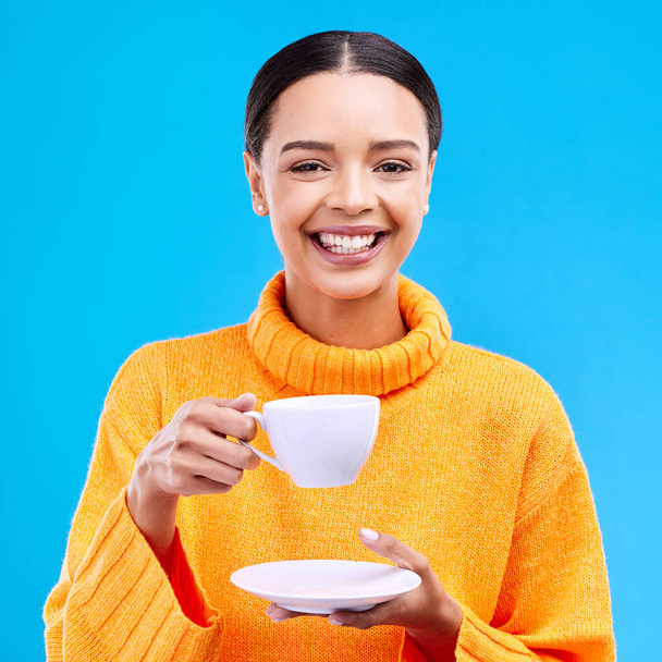 Tea, woman portrait and smile in studio with happiness, latte or matcha mug. Isolated, blue background and happy female model or young person smiling with casual winter fashion, joy and coffee drink. - Foto, Imagem