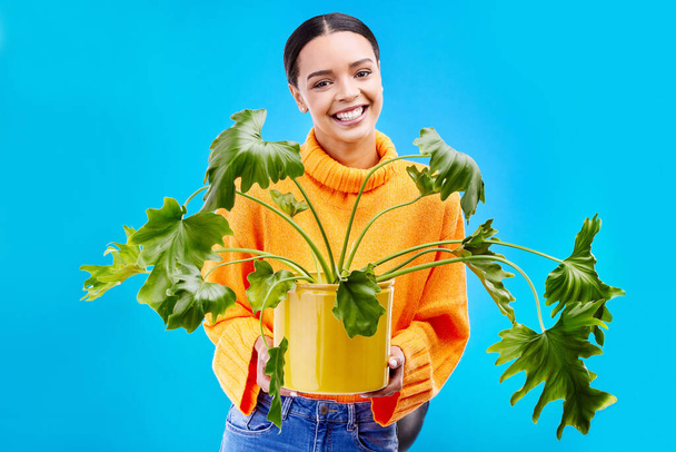 Ritratto di donna in studio con pianta di casa, sorriso o felicità per piante su sfondo blu. Giardinaggio, hobby sostenibile o verde per felice gen z ragazza su spazio mockup o negozio di giardinaggio ecologico - Foto, immagini