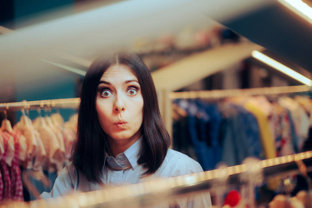 Vicces nő keres ruhák egy divat boltban - Fotó, kép