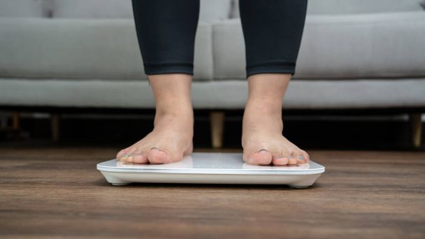 足は体重管理のため電子スケールに立っています。ダイエットコントロールのためのキログラムで測定器. - 写真・画像