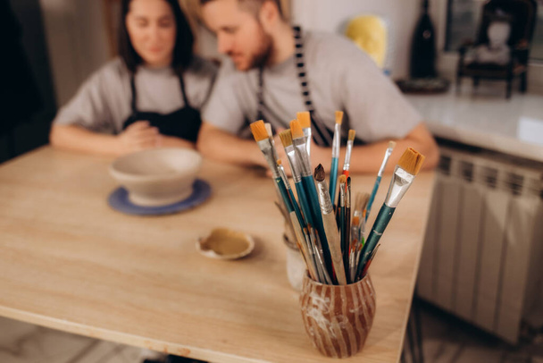 Couple in love working together in potter studio workshop - Фото, зображення