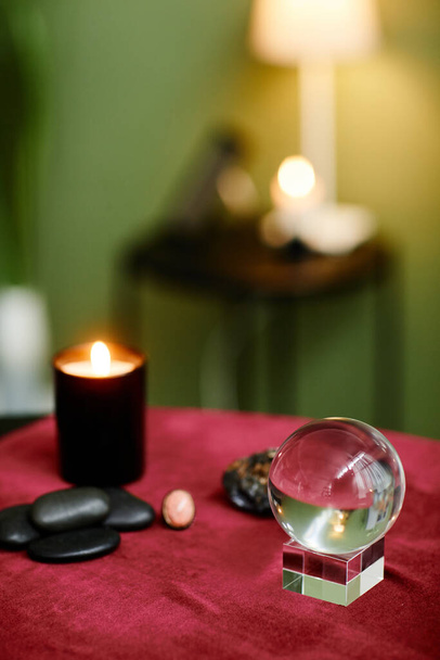 Vertical background image of crystal ball and candles on red velvet table in fortune tellers shop, copy space - Foto, imagen
