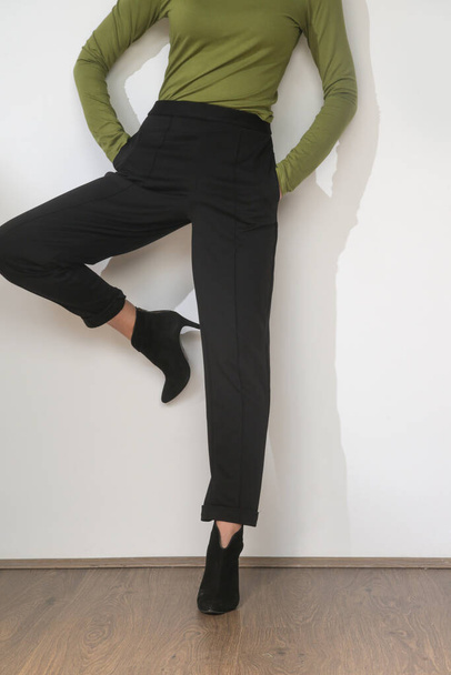 Serie of studio photos of young female model wearing comfortable basic outfit, viscose fitted turtleneck shirt and basic cigarette trousers - Photo, Image