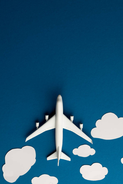 Close up of airplane model with clouds on blue background with copy space. Travel, transport and vacation. - Fotoğraf, Görsel