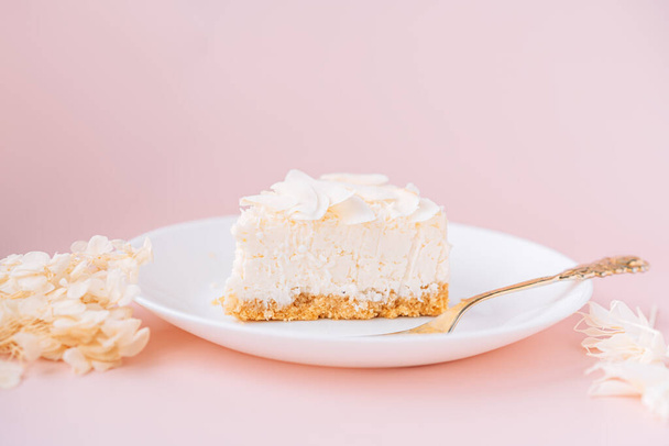 White cheesecake with coconut flavor on plate on pink background. - Foto, Imagem