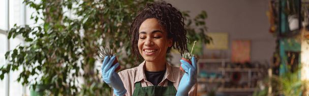 Woman florist takes care of seedlings in floral studio. Blurred background. High quality photo - Foto, Imagem