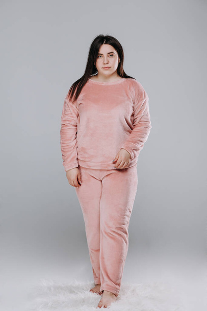 kövér csinos mosolygós lány lila pizsamában. katalógus fotó. az otthoni válasz fogalma - Fotó, kép