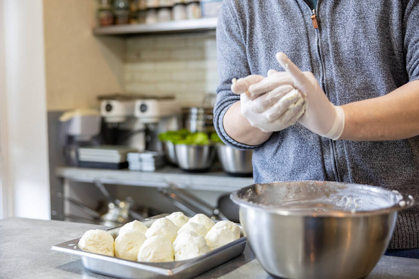 In der Küche formt der Koch mit seinen Händen Quarkkuchen. Vorbereitung auf Ostern - Foto, Bild