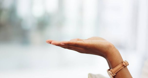 Una mano de mujer abierta mostrando espacio de maqueta en la habitación de un edificio moderno. Primer plano de una niña estirando la palma de su mano con un gesto de toma o celebración con espacio de copia para publicidad, diseño o signo - Foto, Imagen
