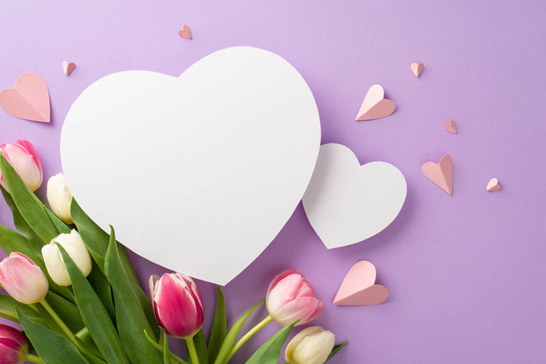 Pretty pink present concept for Mother's Day. Top view flat lay of tulip flowers, paper hearts on a soft pastel purple background with two empty hearts for text or advert - Foto, afbeelding