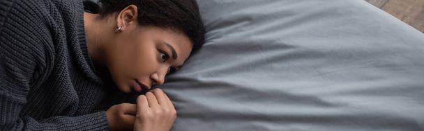 Visão superior da mulher multirracial deprimida com apatia olhando para a cama, banner  - Foto, Imagem