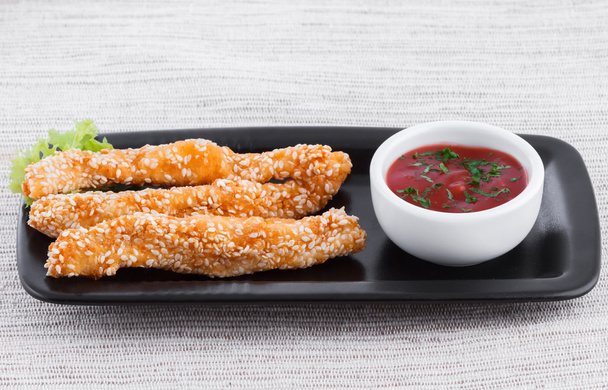 Dedos de pescado frito con salsa y sésamo
 - Foto, Imagen