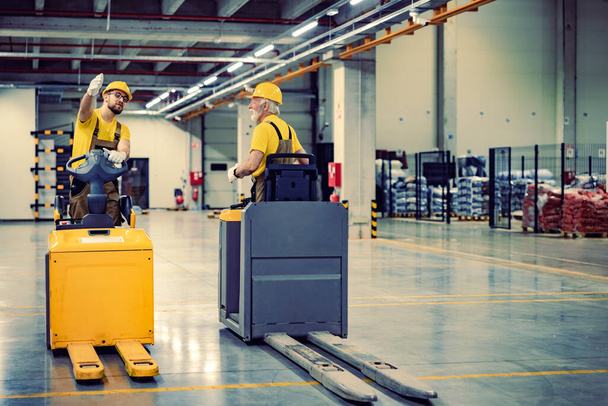 Warehouse man workers with forklift.Retail delivery warehouse full of shelves with goods in cardboard boxes.Product dstribution and delivery logistics. - 写真・画像
