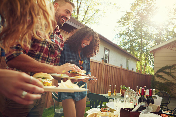 Lets get this barbecue rolling. a group of friends having lunch in their backyard - Foto, Imagem