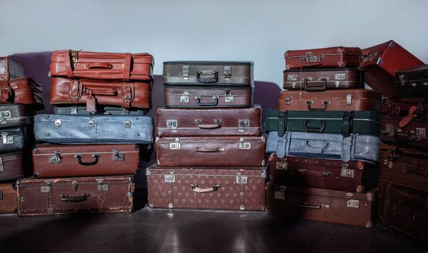 Old suitcases of different sizes and colors, stacked. Selective focus. - Фото, зображення