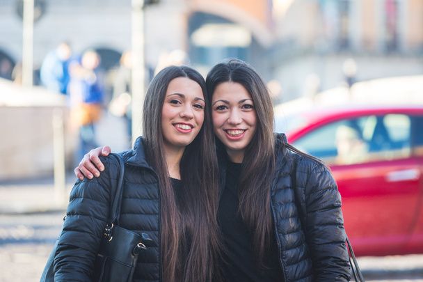 Female Twins Portrait in the City with Traffic on Background. - Foto, afbeelding