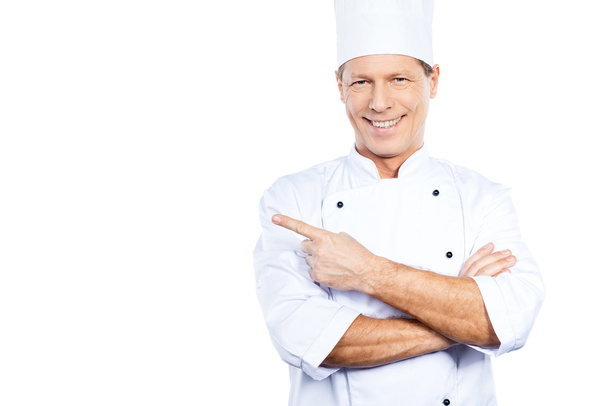Confident mature chef pointing away - Photo, image