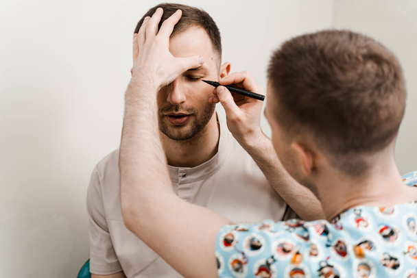 Blefaroplastia para marcação do homem no rosto antes da cirurgia plástica para modificar a região dos olhos na clínica médica - Foto, Imagem