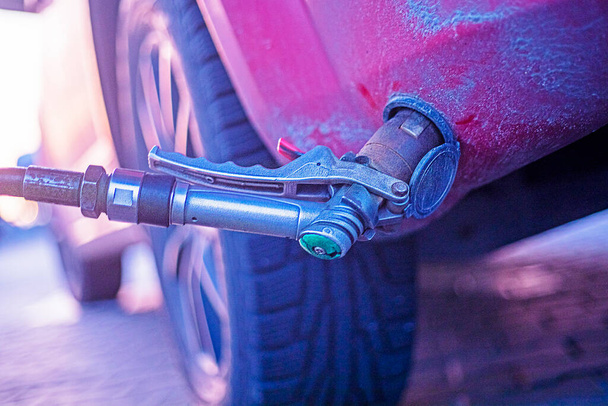 close-up inbrengen van de pomp in de klep van de gasvulmachine bij het benzinestation - Foto, afbeelding