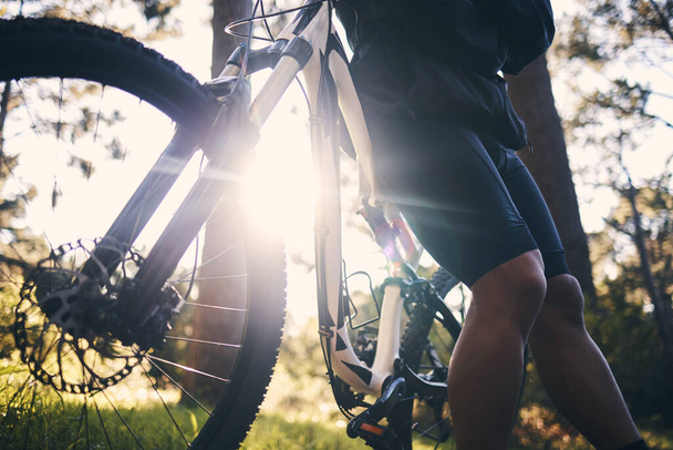Κοντινό πλάνο άνθρωπος, ποδήλατο και φωτοβολίδα στη φύση, πάρκο και σπορ περιπέτεια της ελευθερίας, αθλητής και ηλιοφάνεια. Ποδηλασία, ποδήλατο και ποδηλάτης σε ένα διάλειμμα εξωτερική για φυσική κατάσταση, καρδιο άσκηση και την κατάρτιση για δράση. - Φωτογραφία, εικόνα
