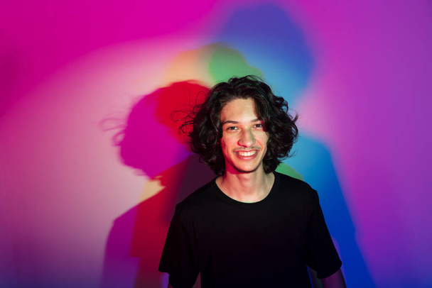 Portrait of young handsome man with colorful shadows on photographic background. rgb colors - Fotó, kép