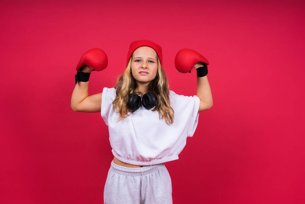 Linda niña en guantes de boxeo en un estudio de fondo rojo - Foto, Imagen