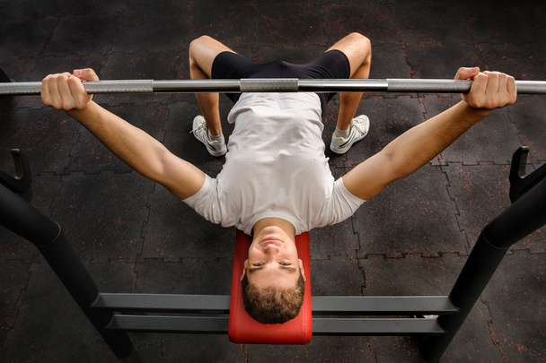 Młody człowiek robi Bench Press Workout w siłowni - Zdjęcie, obraz