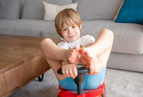 Happy child at home. Little toddler boy driving big toy car and having fun. Smiling kid playing at home. - Foto, Imagen