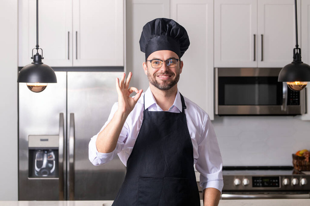 Man chef cooker baker. Millennial male chef in chefs uniform. Chef man cooking on kitchen. Chef cook in hat and apron - Фото, изображение