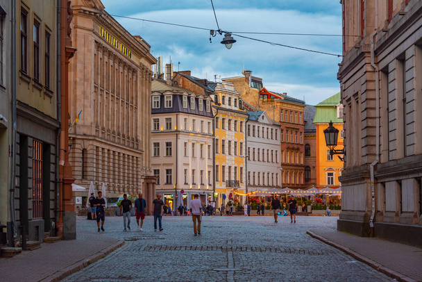 Riga, Latvia, July 8, 2022: Sunset view of Doma Laukums square full of restaurants in the Latvian capital Riga.. - Foto, afbeelding