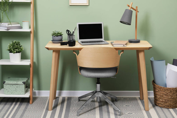 Workplace with laptop, stationery on desk and chair in home office - Fotografie, Obrázek