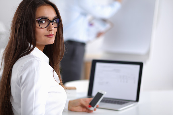 Attractive businesswoman sitting  on desk in the office - Foto, Imagem