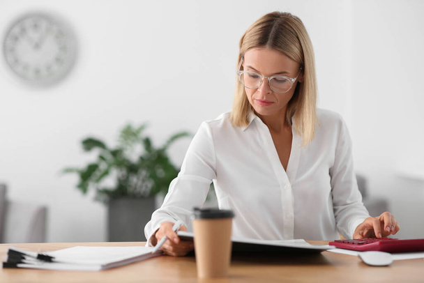 Woman working with documents at wooden table in office - Foto, Imagem