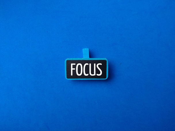 Wooden board with the word FOCUS on a blue background. Business concept. - Zdjęcie, obraz