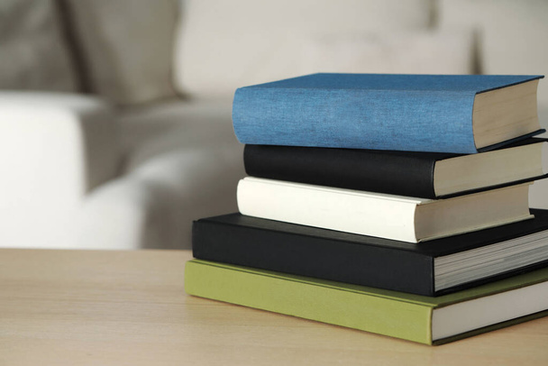 Empilement de livres à couverture rigide sur table en bois à l'intérieur, espace pour le texte - Photo, image
