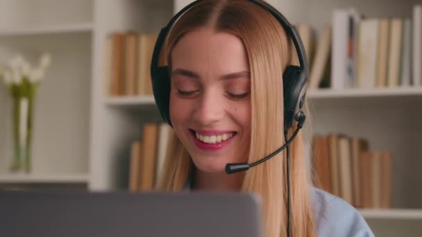 Happy Caucasian smiling woman in headset talking conference call video chat speak at computer laptop at home office job interview distance language course class girl businesswoman help line operator - Footage, Video