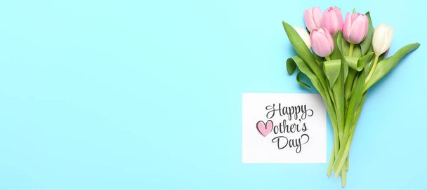 Cartão com texto HAPPY MOTHER 'S DAY e tulipas em fundo azul claro com espaço para texto - Foto, Imagem