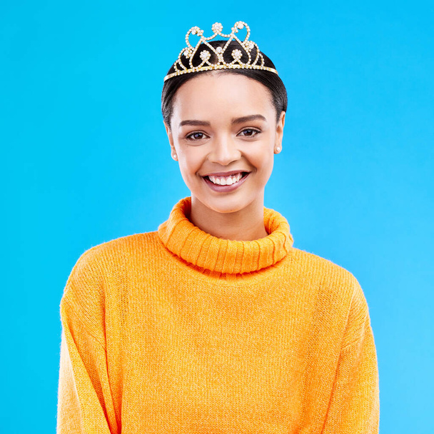 Winner, crown and portrait of woman in studio for celebration, princess and party. Smile, beauty and fashion with female and tiara on blue background excited for achievement, winner and prom event. - Foto, imagen