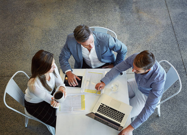 Working together. High angle shot of three businesspeople working in the office - Foto, Imagen