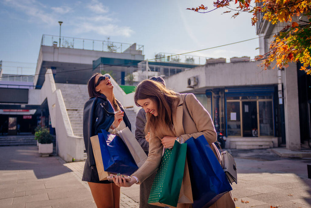 Três meninas adoráveis com sacos de compras sorrindo antes de tirar a selfie - Foto, Imagem