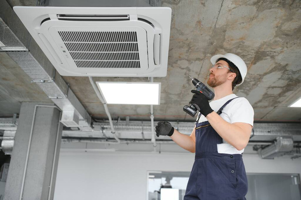 Happy Male Technician Repairing Air Conditioner. - Fotoğraf, Görsel