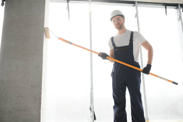 Worker renewing apartment on wall background - Photo, image