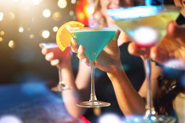 パーティーを始めるには飲み物が必要です。ナイトクラブでカクテルを飲む女性は - 写真・画像