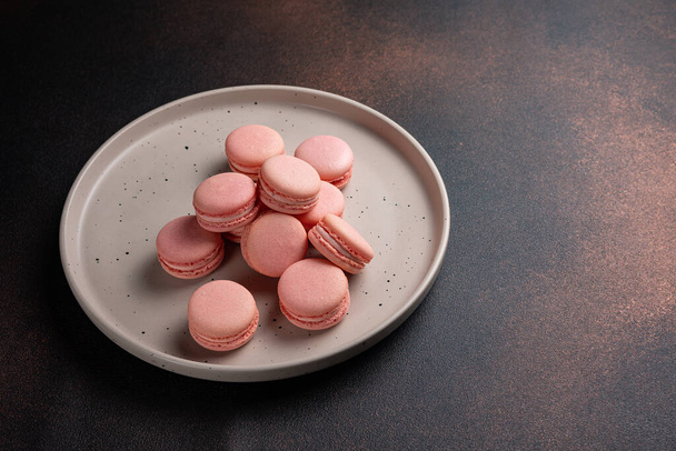 Pink macaroons on a plate on a dark table - Foto, Bild