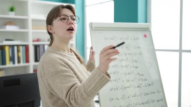 Fiatal szőke nő tanár elmagyarázza matematika óra könyvtár egyetem - Felvétel, videó