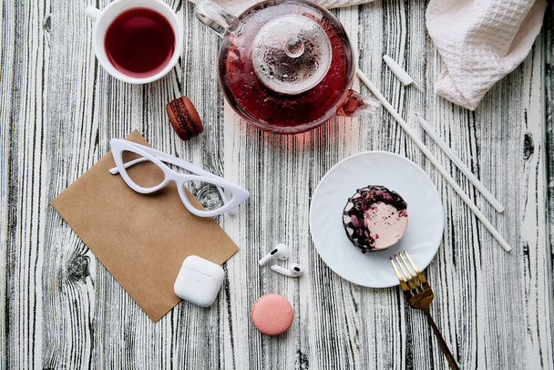 Жіноча естетика рожевий здоровий десерт з натуральним чаєм, навушники та конверт глузують. Жіночий стиль життя фону
. - Фото, зображення