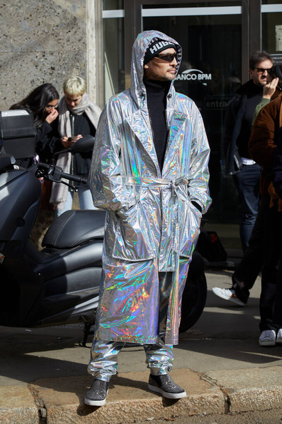 MILAN, ITALY - FEBRUARY 25, 2023: Man with silver, iridescent trench coat before Dolce and Gabbana fashion show, Milan Fashion Week street style - Foto, Imagen