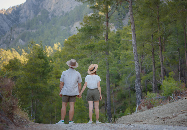 新鮮な空気を取り入れ屋外活動に従事するという概念です。若い夫婦を愛し、自然を背景に一緒に抱き合って笑顔。トルコに山の森の散歩 - 写真・画像